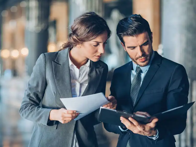 Serious business persons looking at documents.