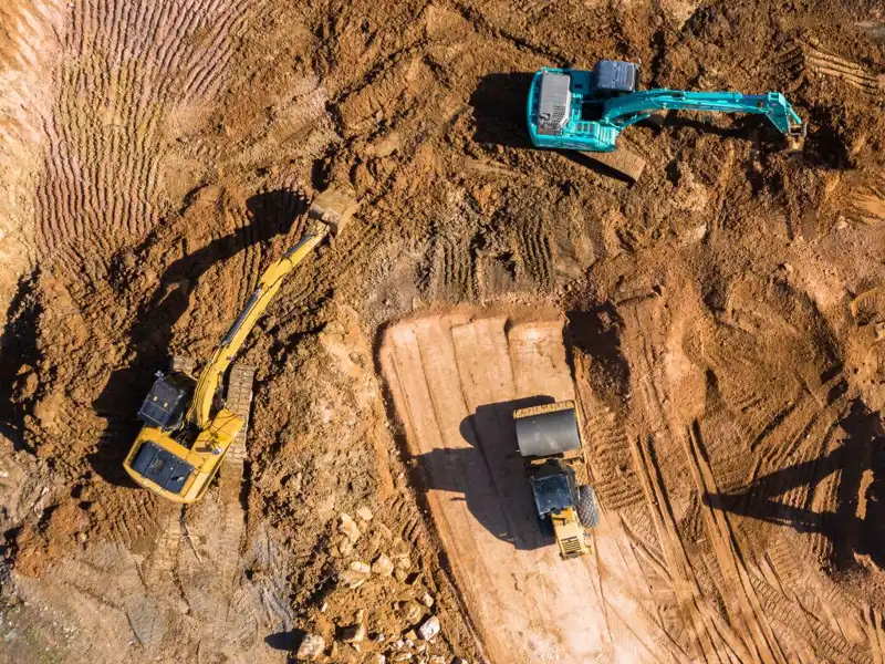 Aerial view of a construction site with bulldozers moving dirt.
