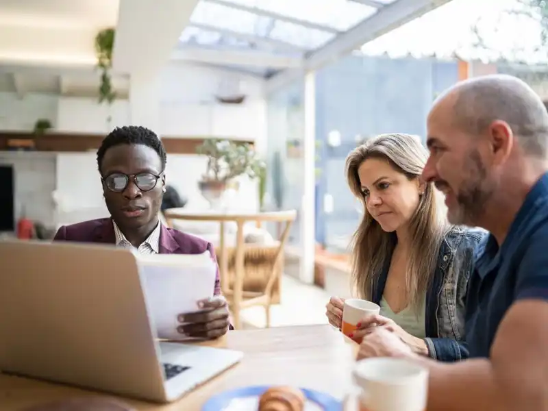 Finance advisor doing a meeting with couple at home.