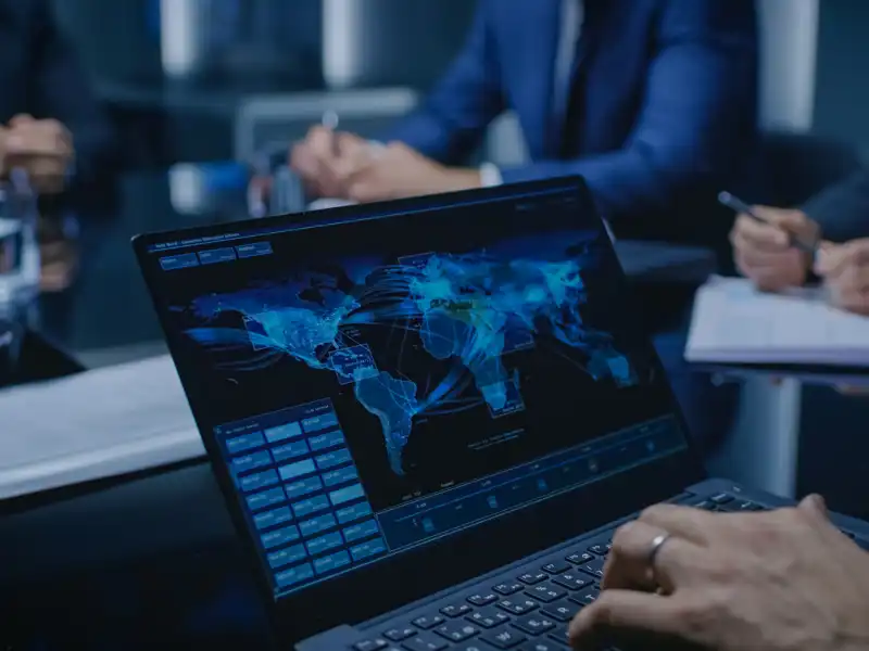 Closeup of a man on a laptop during a business meeting.