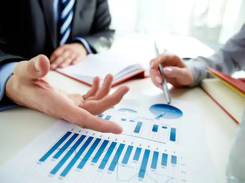 Image of male hand pointing at business document during discussion at meeting.