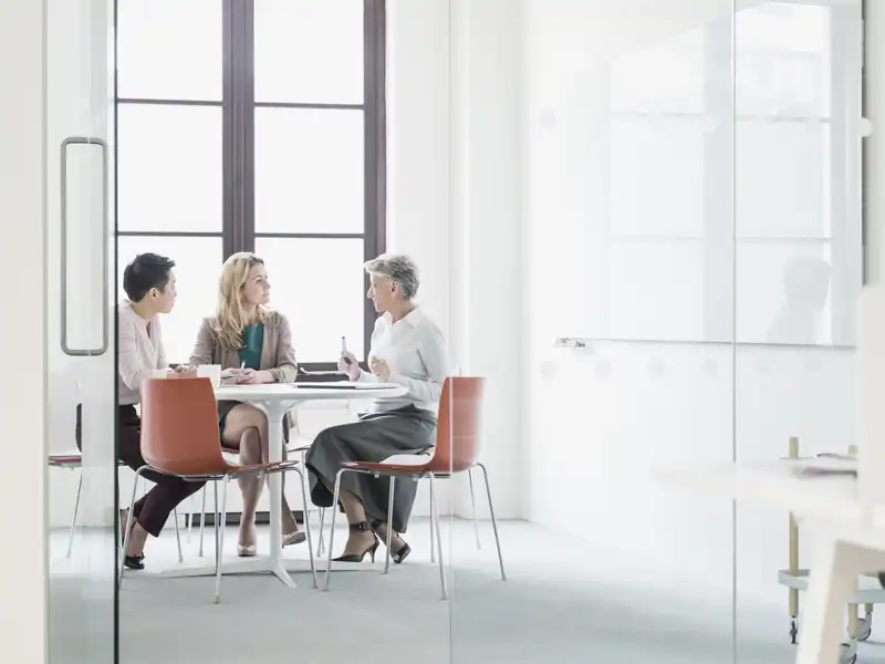Three coworkers sitting in a modern office.