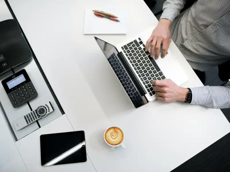Person seated at desk, working on laptop