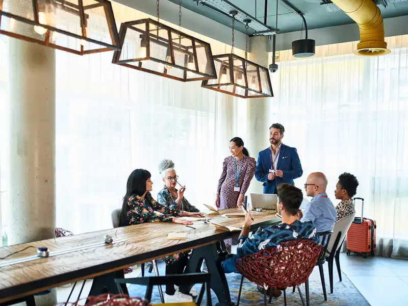 Group of people sitting or standing at a large table.