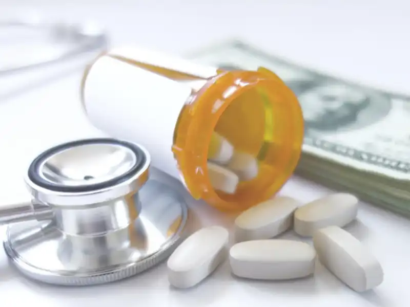 a prescription drug bottle open with a stethoscope and money in the background