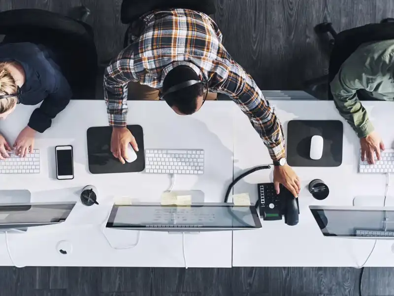 aerial view of three workers sitting at computers