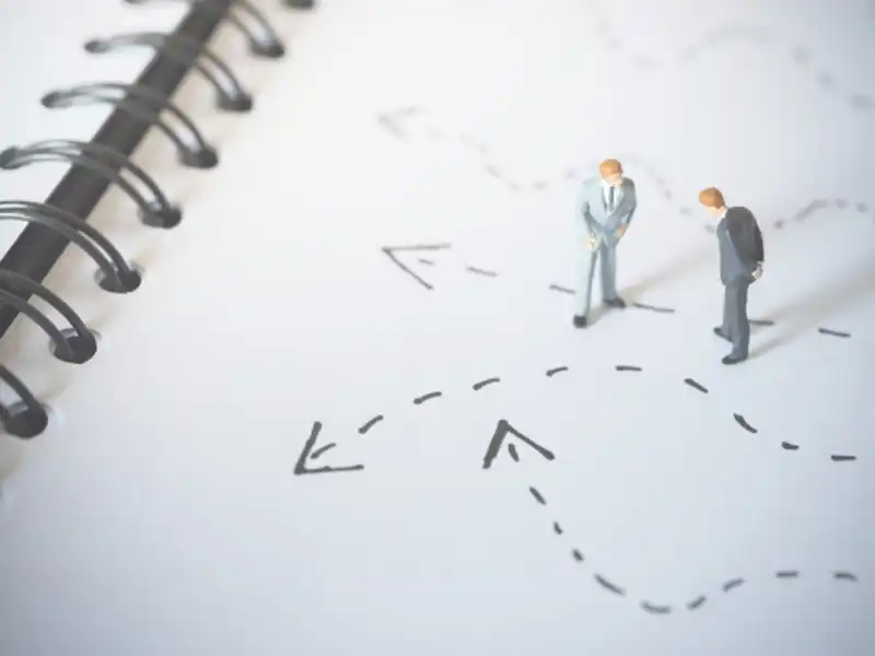 two toy men on paper with arrows drawn on it