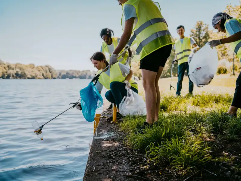 Volunteers picking trash out of a lake.