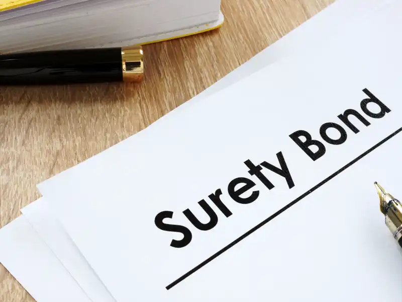 Image of a surety bond and a black pen.
