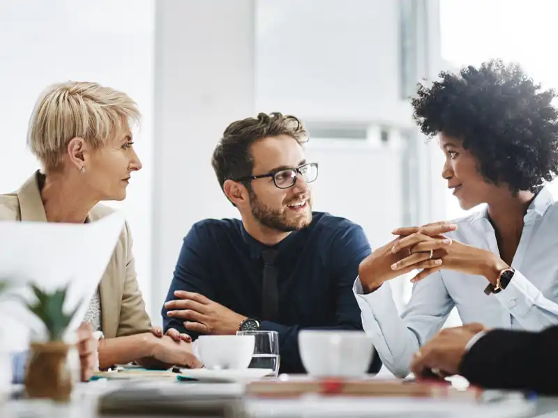 Group of coworkers sitting at a table talking.