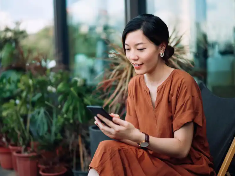 A woman looks at a phone in a nursery