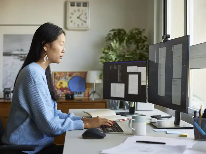 A woman works at a desk with a computer