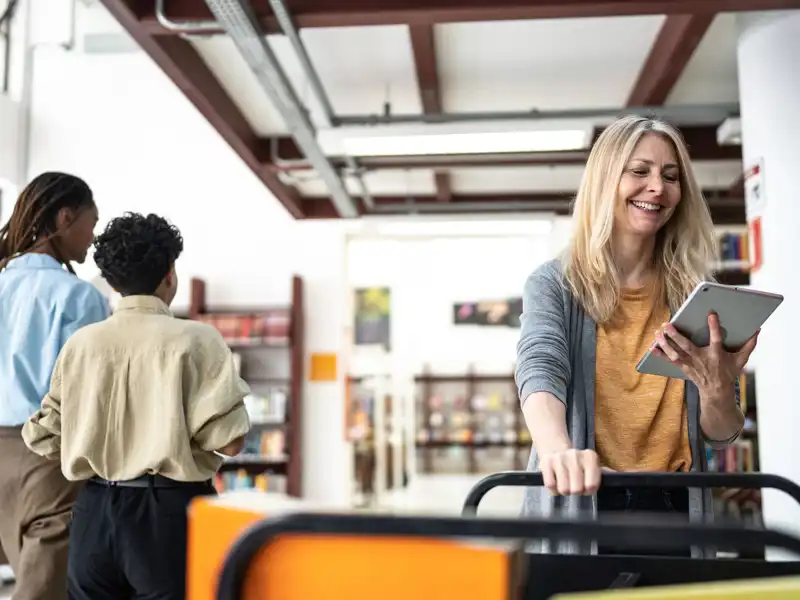 Woman in a library using tablet.