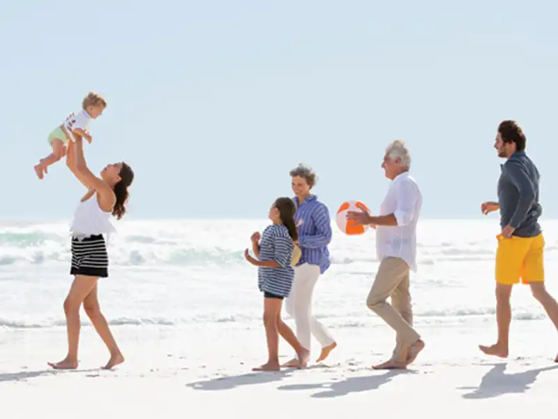 A family enjoys a sunny day walk on the beach