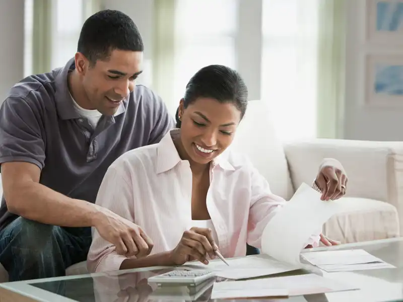 a young couple sitting at their coffee table going over paperwork