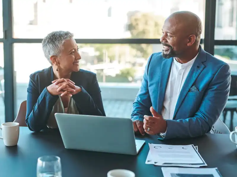 Leaders sitting at a table in front of a laptop