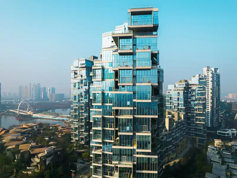 A modern architecture apartment building towers above a city skyline.
